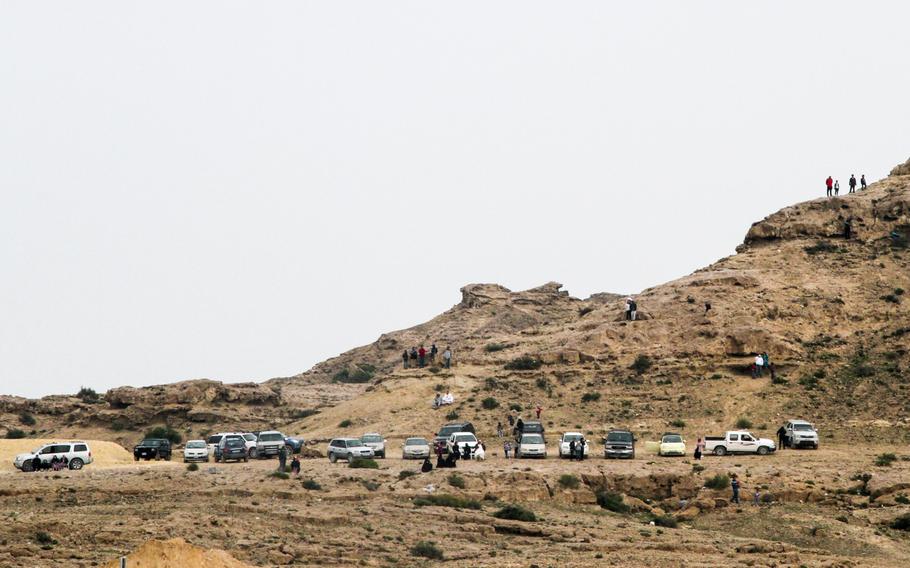 People without tickets climb adjacent hills to Sakhir Airbase to get a good view of performing aircraft at the Bahrain International Airshow Jan 18, 2014.