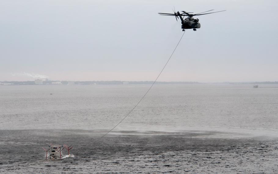An MH-53E Sea Dragon helicopter assigned to Helicopter Mine Countermeasures Squadron 14 tows a MK-106 tow sled during airborne mine countermeasure training in St. Andrew Bay near Naval Surface Warfare Center Panama City on March 5, 2013. The tow sled is a magnetic influence sweep system used in airborne mine countermeasure missions.