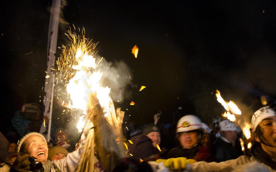 Spectators narrowly avoid being struck with a lit torch during the one-hour battle at the Dosojin Fire Festival.