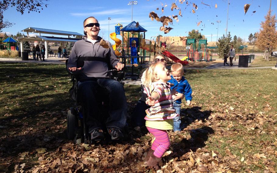 Matt Keil, a former Army staff sergeant who has been a quadriplegic since a sniper shot him in the neck in Iraq, plays at a park near his Colorado home with his three-year-old twins, Faith and Matthew, and his wife, Tracy. The family will receive financial insurance through the Wounded Warrior Project's new long-term trust program.