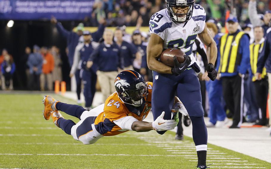 Seattle Seahawks' Doug Baldwin (89) runs from Denver Broncos' Champ Bailey (24) after making a reception during the first half of the NFL Super Bowl XLVIII football game Sunday, Feb. 2, 2014, in East Rutherford, N.J. (AP Photo/Ted S. Warren)