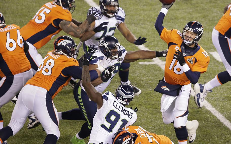 Denver Broncos' Peyton Manning (18) throws a pass during the first half of the NFL Super Bowl XLVIII football game against the Seattle Seahawks Sunday, Feb. 2, 2014, in East Rutherford, N.J. (AP Photo/Charlie Riedel)