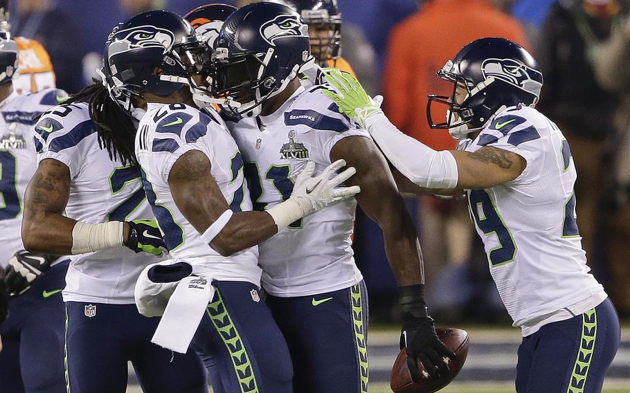 Seattle Seahawks strong safety Kam Chancellor (31) celebrates with teammates after intercepting a pass during the first half of the NFL Super Bowl XLVIII football game against the Denver Broncos Sunday, Feb. 2, 2014, in East Rutherford, N.J. (AP Photo/Gregory Bull)