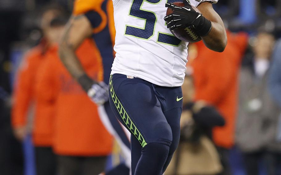Seattle Seahawks' Malcolm Smith (53) celebrates as he returns an interception 69-yards for a touchdown during the first half of the NFL Super Bowl XLVIII football game against the Denver Broncos Sunday, Feb. 2, 2014, in East Rutherford, N.J. (AP Photo/Evan Vucci)