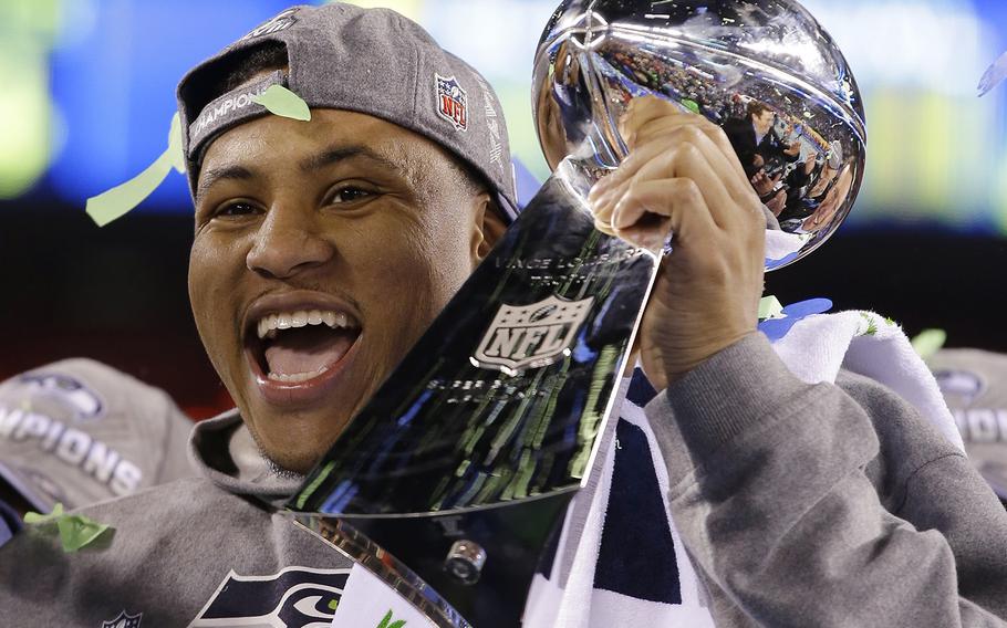 Seattle Seahawks' Malcolm Smith holds the Vince Lombardi Trophy after the NFL Super Bowl XLVIII football game against the Denver Broncos Sunday, Feb. 2, 2014, in East Rutherford, N.J. The Seahawks won 43-8. (AP Photo/Matt Slocum)