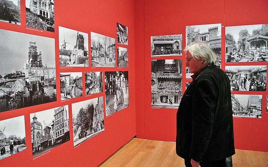 A visitor to the "Esprit Montmartre: Bohemian Life in Paris around 1900" exhibit at the Schirn Kunsthalle in Frankfurt, Germany, looks at photos of Montmartre taken at the end of the 19th and beginning of the 20th century, Thursday, Feb. 6, 2014.