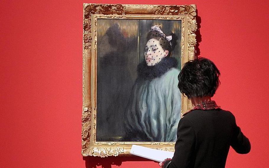 A visitor looks at Louis Anquetin's "La femme à la voilette" at the "Esprit Montmartre: Bohemian Life in Paris around 1900" exhibition at the Schirn Kunsthalle in Frankfurt, Germany, Thursday, Feb. 6, 2014. The painting is also featured on the exhibit's poster and catalog.