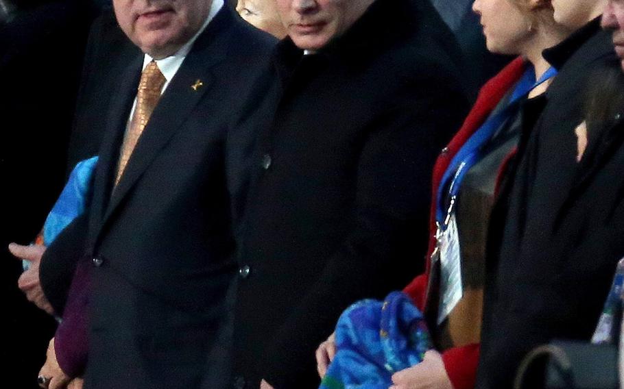 Russian President Vladimir Putin, center, and International Olympic Committee President Thomas Bach, center left, stand together during the Opening Ceremony for the Winter Olympics at Fisht Olympic Stadium in Sochi, Russia, Friday, Feb. 7, 2014.