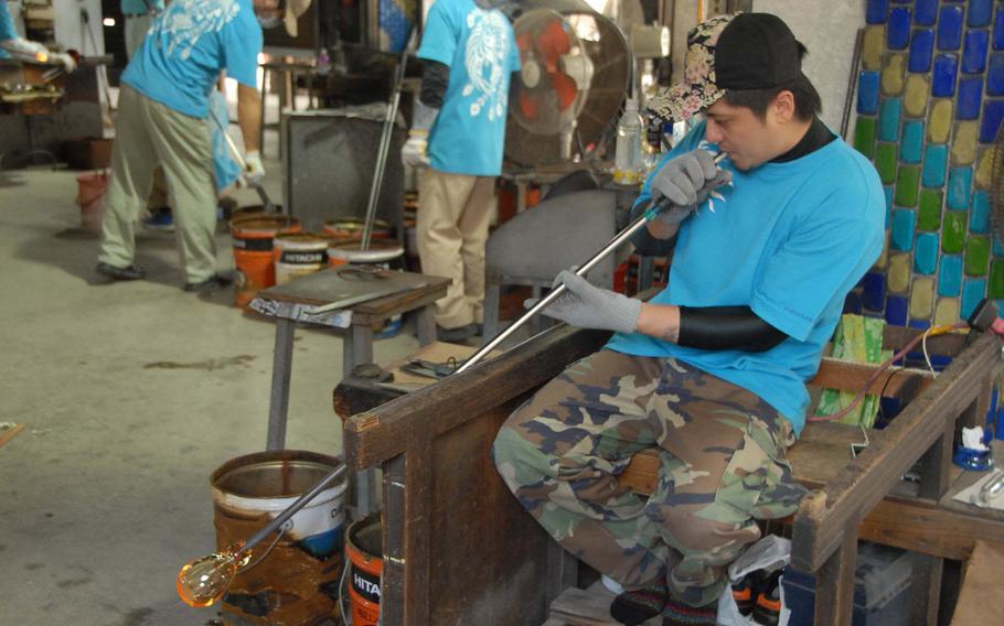 A blower works on a new piece near the kilm at Ryukyu Glass Craft on Okinawa.