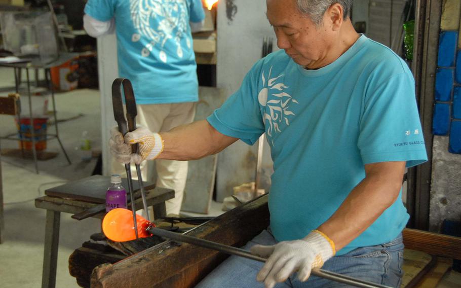 A worker slowly forms a new glass piece at the Ryukyu Glass Craft factory on Okinawa.