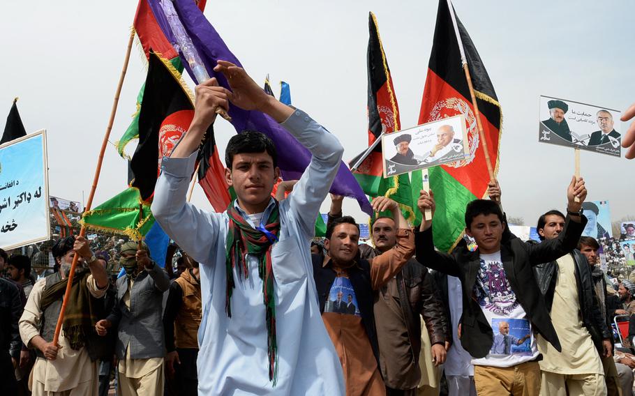 Afghans wave flags and banners as they march at a rally for presidential candidate Ashraf Ghani in Kabul on April 1, 2014. Jubilant rallies contrasted with fears of violence and concerns over corruption as Afghans went to the polls.