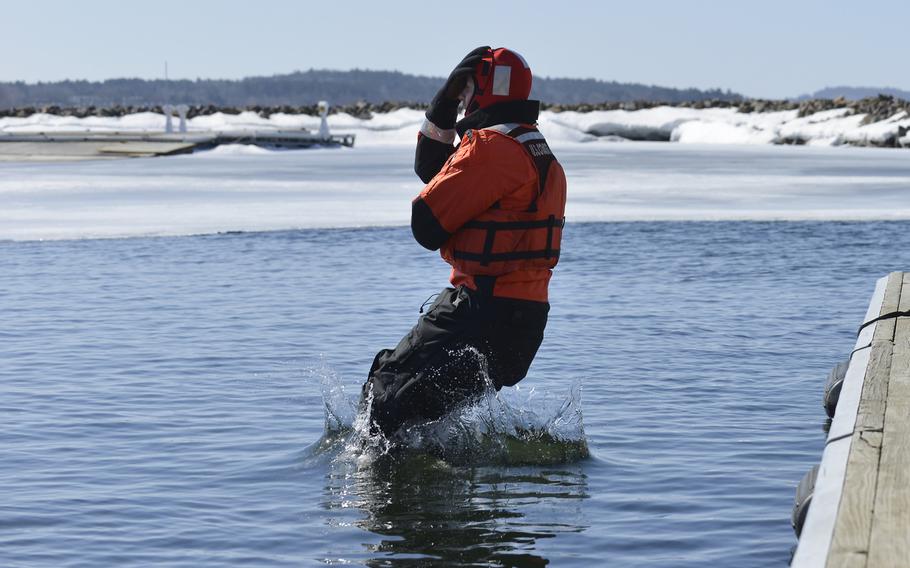 Fireman Brad Cole, from Coast Guard Station Burlington, Vt., jumps into the water during ice-rescue training on Lake Champlain in Burlington, Vt., on April 1, 2014.