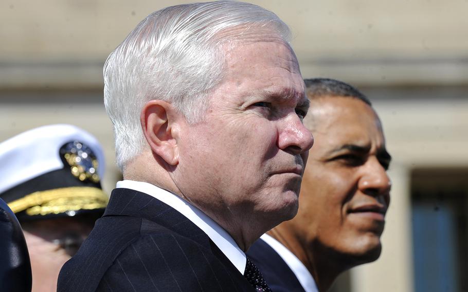 Then-Defense Secretary Robert M. Gates, front, stands with President Barack Obama as they listen to the U.S. Army Old Guard Fife and Drum Corps during an Armed Forces Farewell Tribute in honor of Gates at the Pentagon on June 30, 2011.