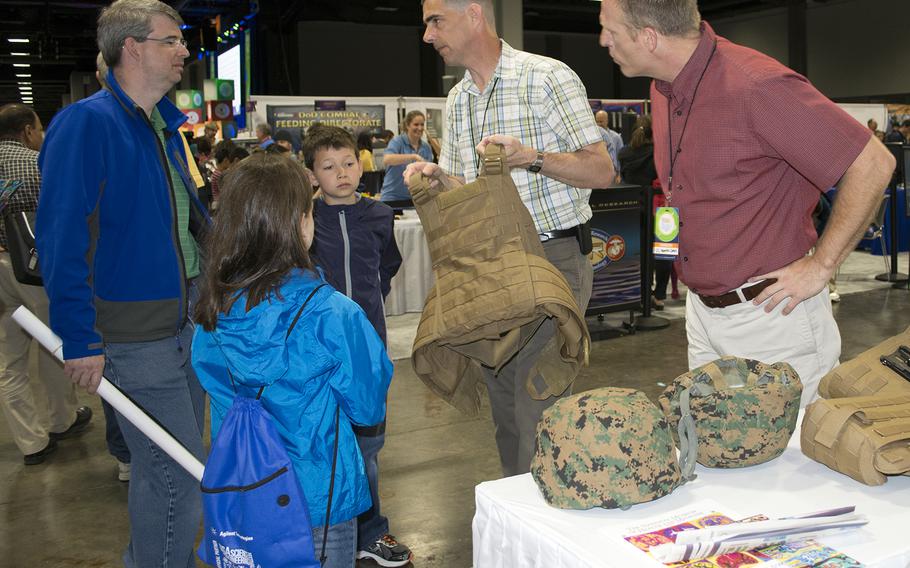A family looks at some military vests during the USA Science and Engineering Festival on April 25, 2014 in Washington, D.C.