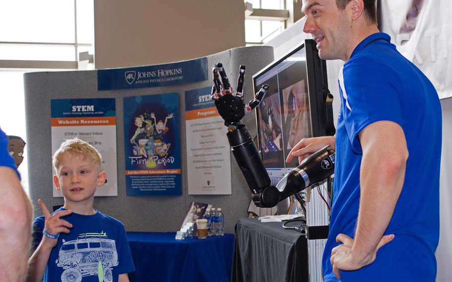 A boy mimics the hand movements of a prosthetic arm at the USA Science and Engineering Festival on April 25, 2014 in Washington, D.C.