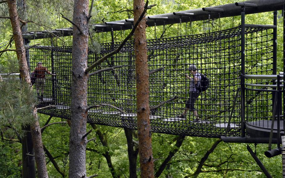 A visitor gingerly negotiates a segment of the treetop trail near the town of Fischbach bei Dahn that consists of metal discs, suspended by chains, that sway when stepped upon. Most of the footpath, however, is similar to a boardwalk. 
