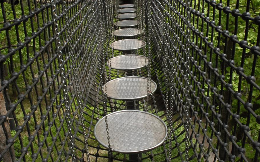 One segment of the treetop trail near the town of Fischbach bei Dahn, Germany, consists of a series of metal discs, suspended by chains inside a rope cage. Opened in 2003, the trail is promoted as Germany's first canopy walk.