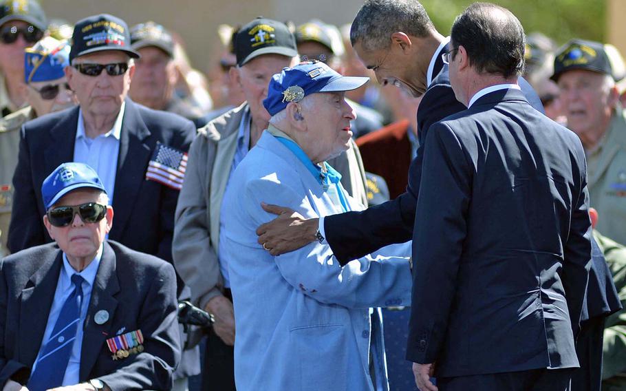 President Barack Obama shakes hands with World War II veterans following the conclusion of the ceremony at Normandy American Cemetery in Colleville-sur-Mer, on June 6, 2014, marking the 70th anniversary of D-Day. At right is French President Francois Hollande.