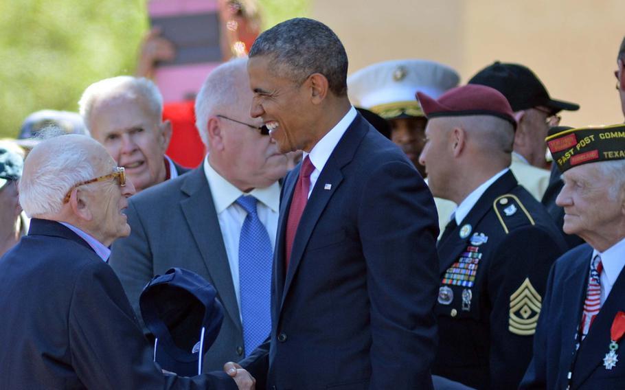 President Barack Obama shakes hands with World War II veterans following the conclusion of the ceremony at Normandy American Cemetery in Colleville-sur-Mer, Friday, June 6, 2014, marking the 70th anniversary of D-Day.
