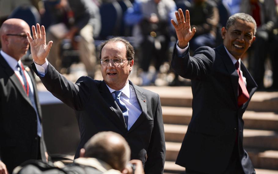 French President Francois Hollande and U.S. President Barack Obama wave to the crowd as they depart the 70th anniversary D-Day commemoration June 6, 2014, at the Normandy American Cemetery Colleville-sur-Mer, Normandy, France.