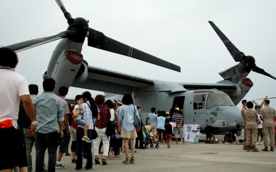 Visitors to Marine Corps Air Station Futenma, Okinawa, on June 8, 2014, line up to catch a glimpse of the Marines' newest aircraft to the island -- the MV-22 Osprey.