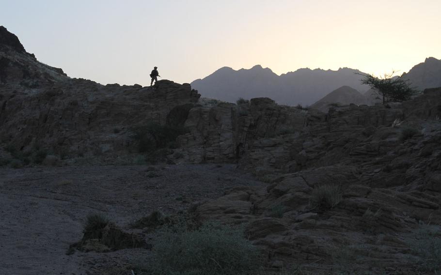 A U.S. Marine stands guard on a ridge, providing security for fellow Marines on a 4 mile hike in a mountainous area near Aqaba, Jordan, June 6.