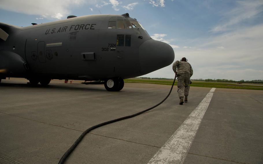 U.S. Air Force Master Sgt. Daniel Belk, crew chief, 302nd Airlift Wing, Peterson Air Force Base, Colorado, runs a power cable toward a C-130 Hercules aircraft during Maple Flag in Edmonton/Cold Lake, Alberta, Canada, on Friday, May 30, 2014. Maple Flag is an international exercise designed to enhance the interoperability of C-130 aircrews, maintainers and support specialists in a simulated combat environment.