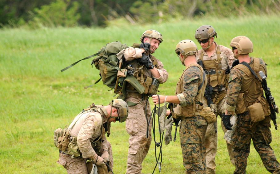 Marines with 3rd Reconnaissance Battalion gather their gear after completing another cycle of fast-rope training in northern Okinawa, June 17, 2014.