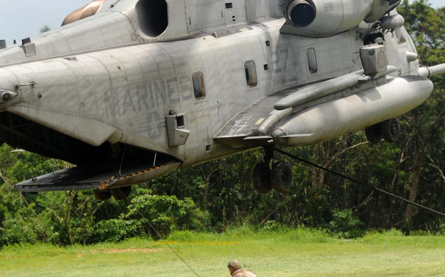 A Marine with 3rd Reconnaissance Battalion ensures that the gear is out of the way before the CH-53 Super Stallion, from Marine Heavy Helicopter Squadron 361, lands during fast-rope training in northern Okinawa, June 17, 2014.
