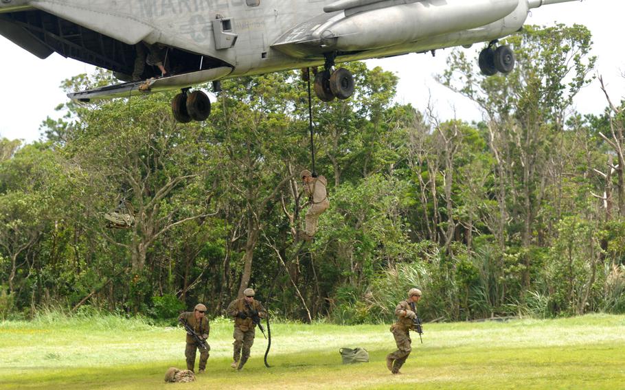 Marines with 3rd Reconnaissance Battalion move into position during fast-rope training in northern Okinawa, June 17, 2014.