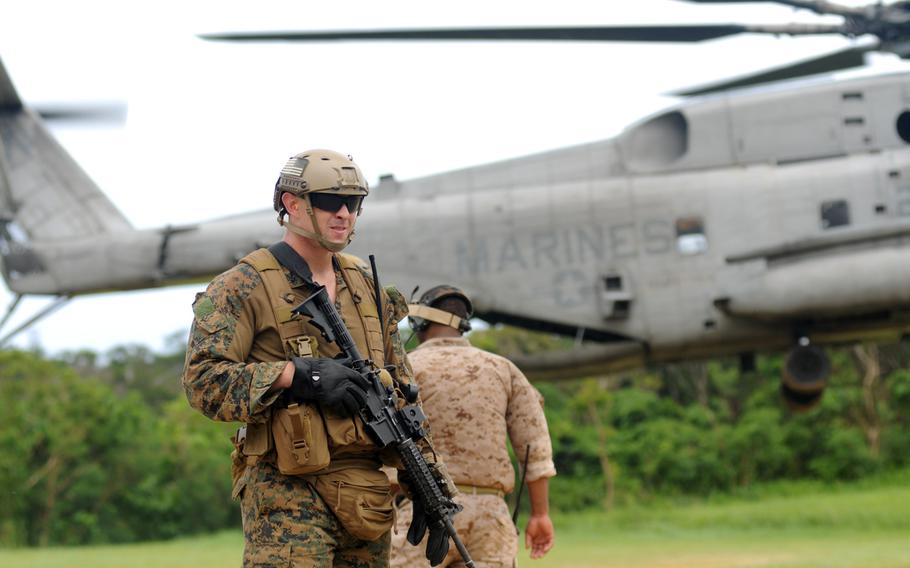 A Marine with 3rd Reconnaissance Battalion prepares to board a CH-53 Super Stallion during fast-rope training in northern Okinawa, June 17, 2014.