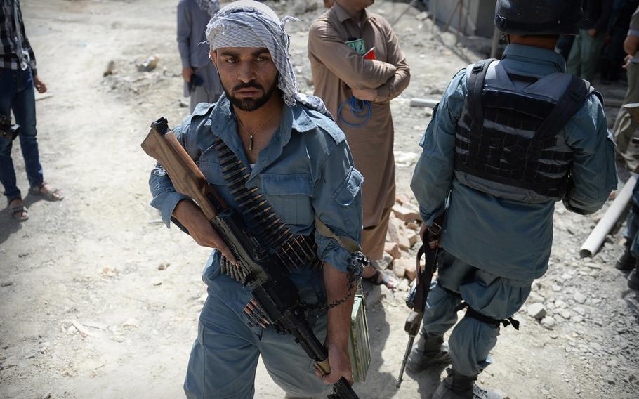 An Afghan policeman leaves the building where four Taliban militants lay dead after a firefight near the Kabul airport on Thursday, July 17, 2014. International military officials say Afghan forces in Kabul have become adept at reacting to such attacks.