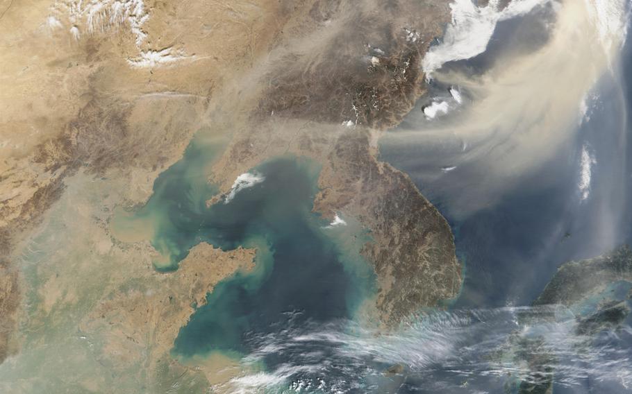 A large, dense plume of dust blows southward and eastward from the desert plains of Mongolia over Japan and the Pacific Ocean. The massive dust storm (brownish) can easily be distinguished from clouds (bright white).