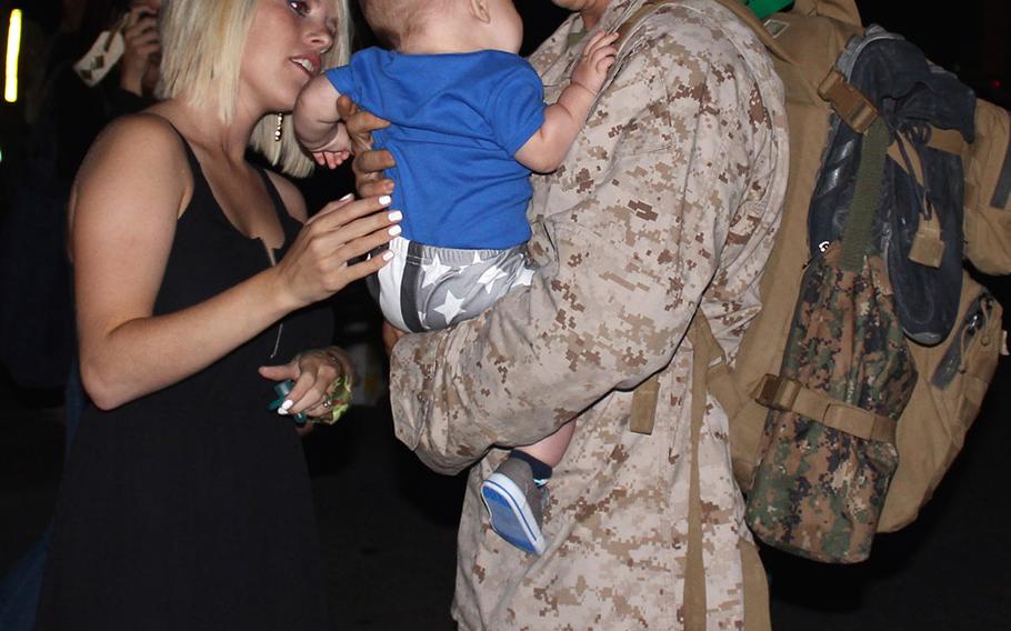 Cpl. Nickolas Collins meets his son, 6-month-old Karson Collins, for the first time Wednesday morning at Camp Pendleton, Calif. Collins returned early Wednesday from a seven-month deployment to Camp Leatherneck, Afghanistan, with Tango Battery, 5th Battalion, 11th Marine Regiment. Collins' wife, Annette Collins, made a sign saying, "I've waited my whole life to meet you" and dressed Karson in American flag-themed shorts and a shirt printed with "Awesome like daddy" for the occasion.