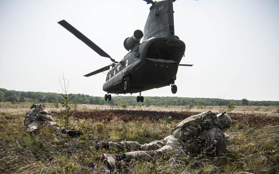 Joint Terminal Air Controllers from the 148th Air Support Operations Squadron, Fort Indiantown Gap, Pa. take cover as a CH-47 Chinook Helicopter from the Illinois Army National Guard flies away during Operation Northern Strike 2014 near Grayling, Mich., Aug. 9, 2014.