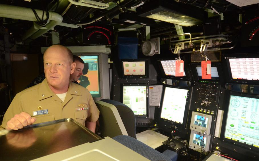 USS Hawaii commanding officer Cmdr. William Patterson explains the fast-attack submarine's controls on Aug. 22, 2014. The Hawaii-based submarine arrived at Yokosuka Naval Base, Japan, on Wednesday.