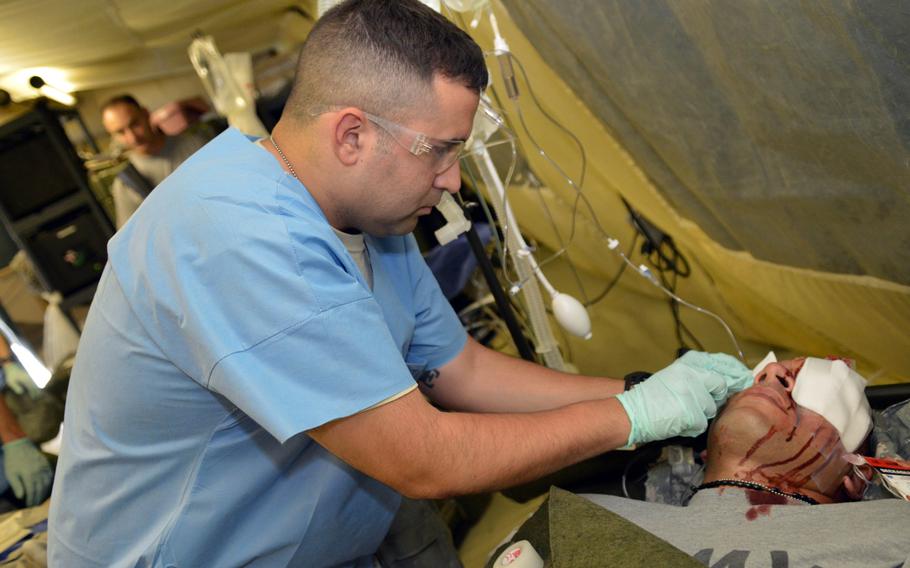 A medical soldier with the 121st Combat Support Hospital changes eye bandages for a simulated medical patient at Camp Humphreys, South Korea on Aug. 22, 2014. Soldiers with the 121st Combat Support Hospital participated in a medical exercise during Ulchi Freedom Guardian.