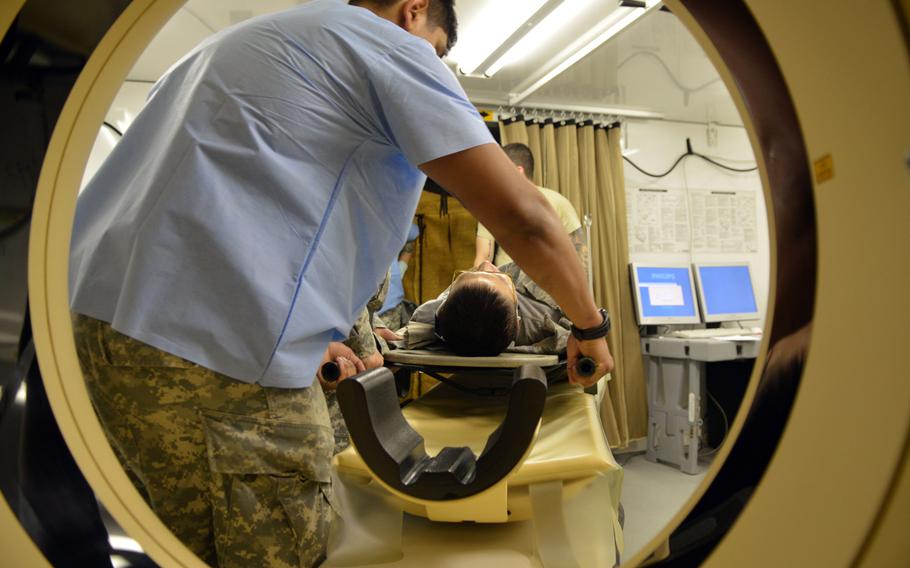 Medical personnel with the 121st Combat Support Hospital places a simulated medical patient on a bed for a CT scan at Camp Humphreys, South Korea on Aug. 22, 2014. Soldiers with the 121st Combat Support Hospital participated in a medical exercise during Ulchi Freedom Guardian.
