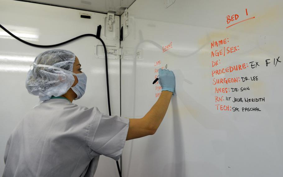 1st Lt. Meridith Jacob writes medical information on a wall of the operating room at Camp Humphreys, South Korea on Aug. 22, 2014. Jacob is a nurse with the 121st Combat Support Hospital.