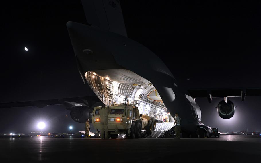 U.S. Air Force Master Sgt. John Sadorf, a C-17 Globemaster III loadmaster, guides the driver of a Heavy Expanded Mobility Tactical Truck as he backs into the aircraft as part of a redeployment mission at Bagram Airfield, Afghanistan on Sunday, July 20, 2014.