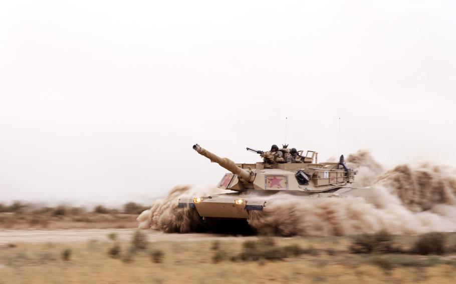 An Abrams M1A1 Tank and its crew of 1st Cavalry Regiment Soldiers plows through thick dusty roads at the Orchard Training Center, Idaho, during tank maneuver engagement training on Aug. 20, 2014.