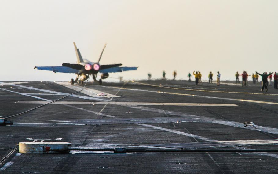 A U.S. Navy F/A-18 lands aboard the USS George H.W. Bush, in the Persian Gulf, Aug. 10, 2014.