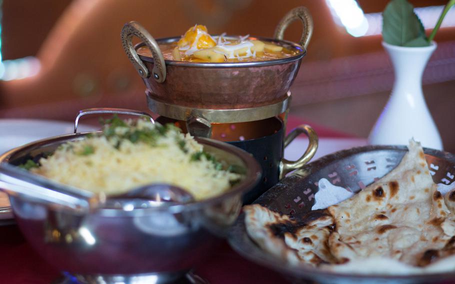 Each meal at Ganesha comes with "naan" and cardamom-infused rice that helps cut the richness of dishes like the mango prawns, seen in the background.