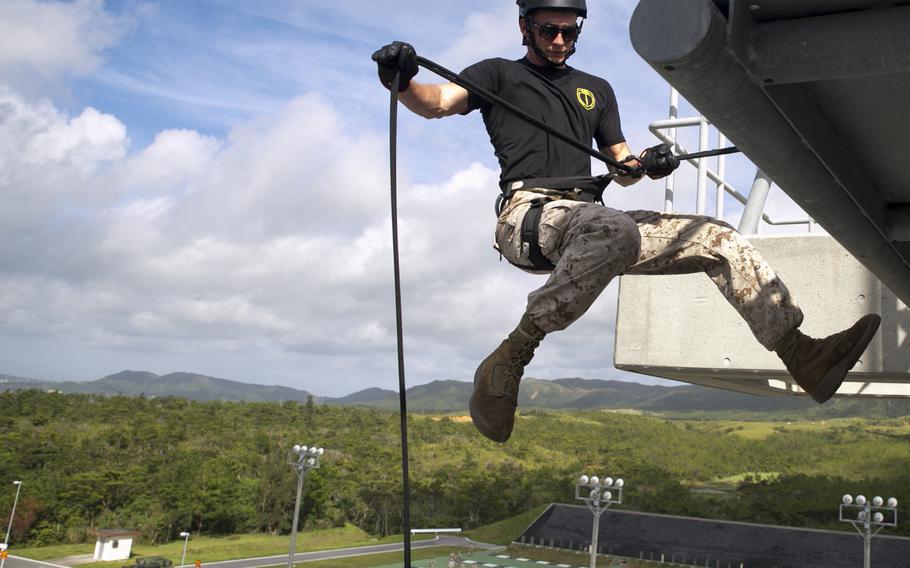 Cpl. Derek Sampson, demonstrates how to properly execute a skid rappel Aug. 13, 2014, at Camp Hansen, Okinawa, during a Helicopter Rope Suspension Techniques Course.
