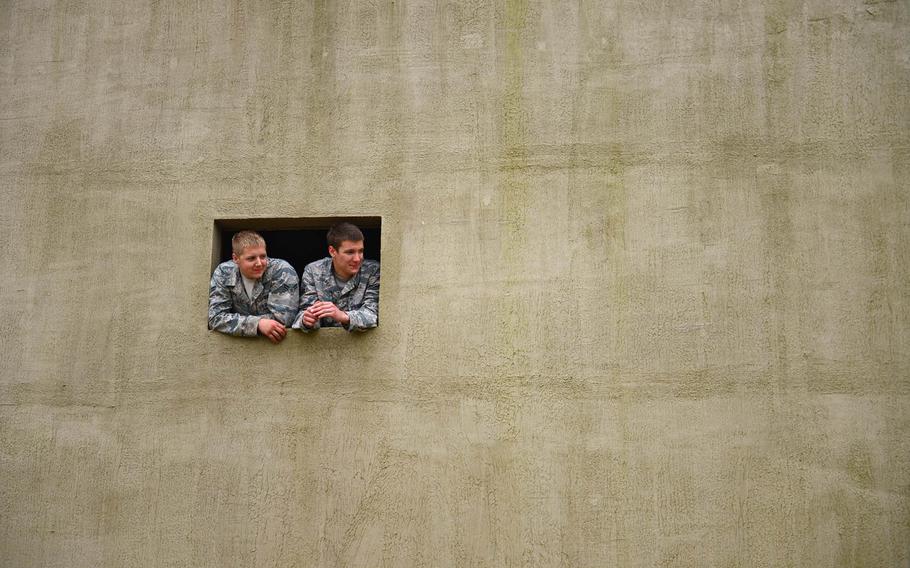Airmen from the 48th Mission Support Group watch a training exercise from a building constructed as a mock Afghan village during a force-on-force exercise at Stanford Training Area, England, on Friday, Sept. 19, 2014. More than 130 48th MSG Airmen participated in the training exercises and practiced scenarios they could possibly encounter in a deployed environment.