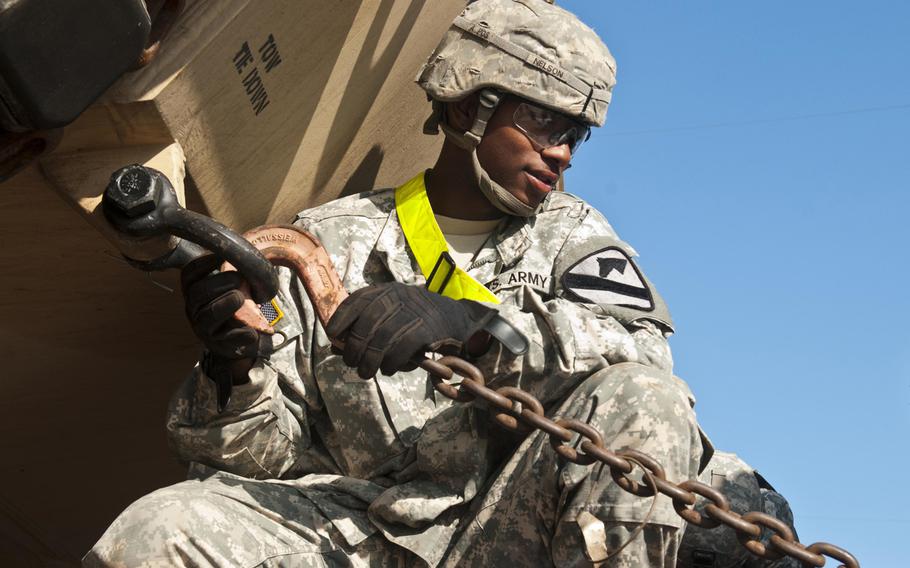 Pvt. Keandre Nelson prepares to unhook a chain securing an M1A2 Abrams tank to a railcar Sept. 25, 2014 at Fort Hood, Texas.