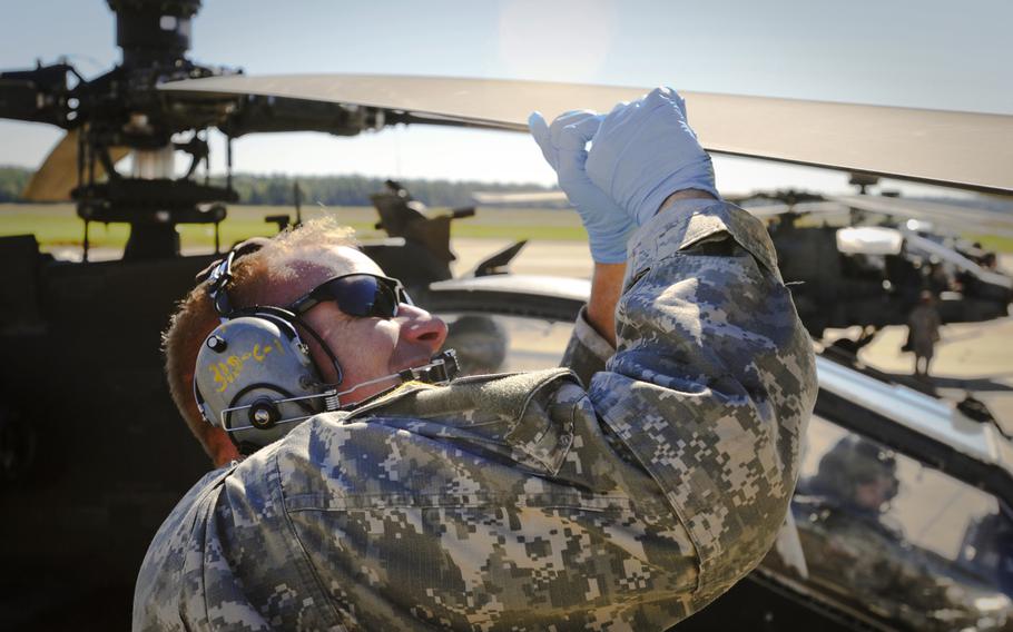 Sgt. Jacob Reese installs a blade wedge on the main rotor of an AH-64D helicopter. Reese is an AH-64D mechanic with the S.C. Army National Guard?s 1-151 Attack Reconnaissance Battalion.