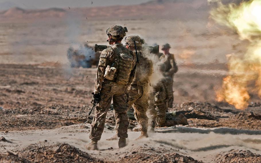 Spc. Franklin Badia shoots an AT4 anti-tank weapon while 1st Lt. James Lockett, (left, and other soldiers observe him at Tarnak Range in Kandahar province, Afghanistan, Oct. 11, 2014. All serve with 4th Infantry Brigade Combat Team, 4th Infantry Division.