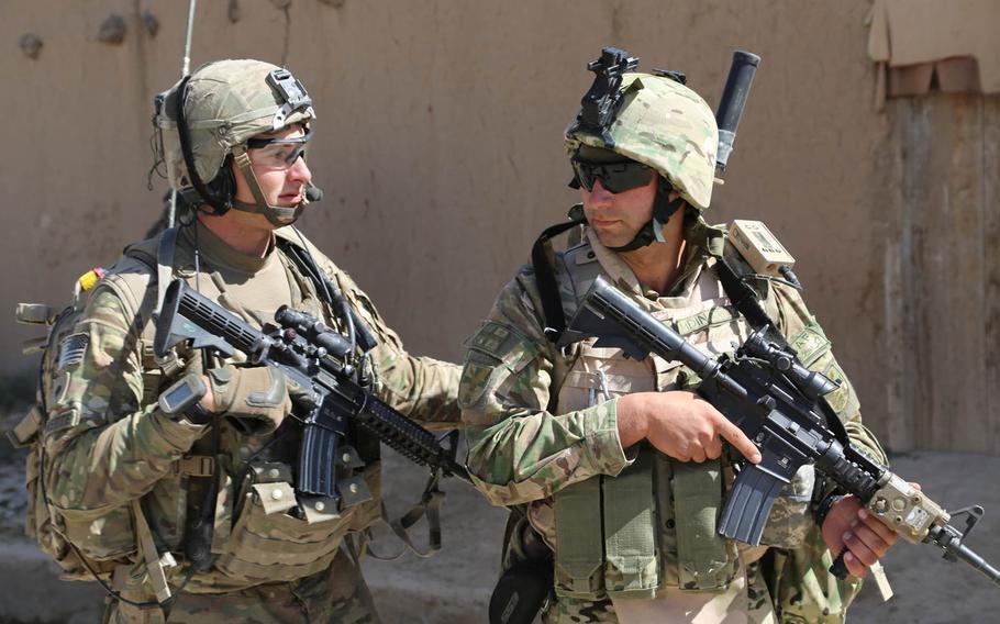 Spc. Cameron Verrette of 1-75 Cavalry, 2nd Brigade Combat Team, 101 Airborne Division, assists Georgian ground forces personnel with the Thor III dismounted CREW system on his back. They were on a foot patrol through the village of Kalanasro, in Bagram, Afghanistan, Oct. 11, 2014. The Thor III is to provide a jammer to counter an array of frequency diverse threats.