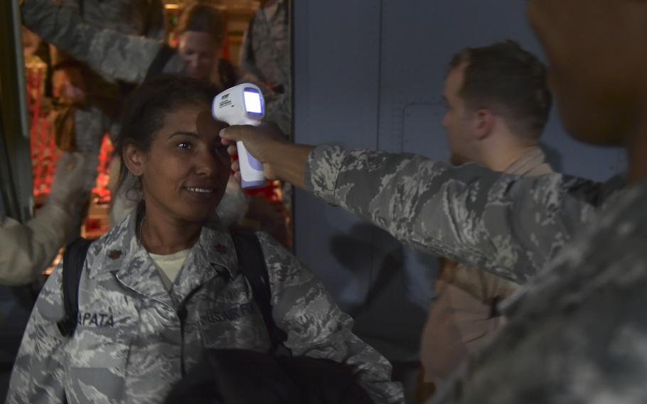 Maj. Mayra Zapata gets her temperature taken by Tech. Sgt. Saquadrea Crosby as she leaves a C-130J Super Hercules at Ramstein Air Base, Germany, Oct. 19, 2014.
